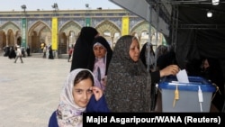 IRAN - An Iranian woman votes at a polling station in a snap presidential election to choose a successor to Ebrahim Raisi following his death in a helicopter crash, Tehran, June 28, 2024.