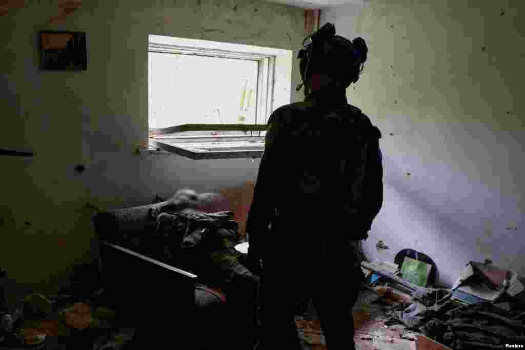 Un soldat ucrainean stă lângă trupul unui alt rus ucis în bătălie.