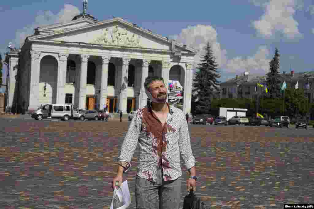 Ukrainanyň Çernihow şäherine edilen rus hüjüminde ýaralanan adam Taras Şewçenko adyndaky Çernihow sebit akademiki aýdym-saz we drama teatrynyň öňündäki Krasna meýdançasyndan ýöräp barýar. 2023-nji ýylyň 19-njy awgusty. (AP/Efrem Lukatsky)