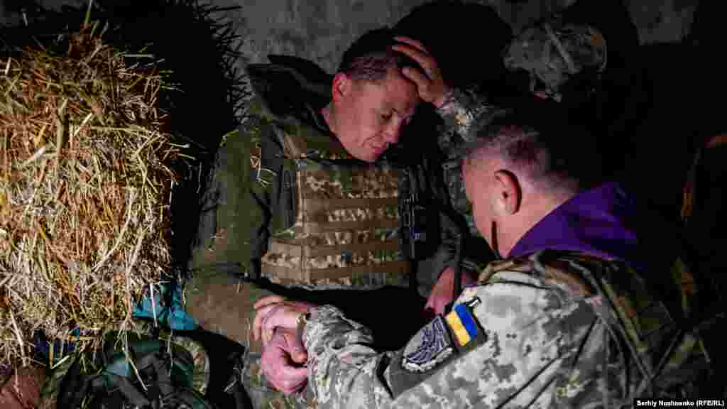 Ҳарбий руҳоний Александр мамлакат шимоли-ғарбида, Харьков вилоятида украин аскари ҳақига дуо қилмоқда. 2022 йил 24 апрель