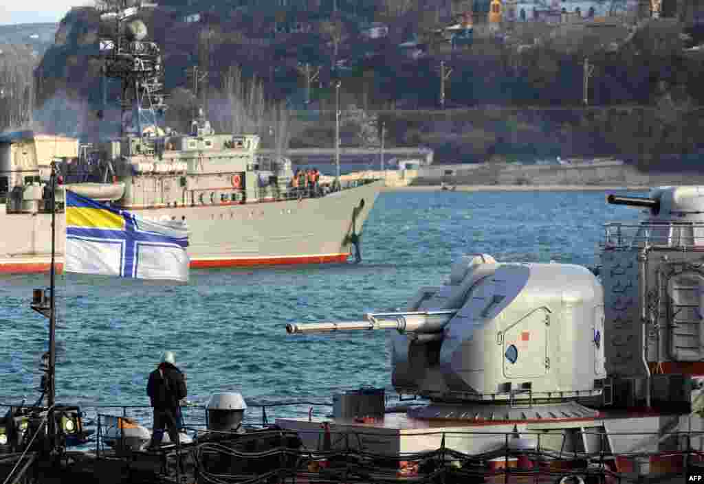 Sevastopol limanında "həbs olunan" Ukrayna donanmasının Slavutich gəmisinin gövdəsində növbə çəkən matros Sevastopol körfəzində patrul xidməti çəkən Rusiya Qara dəniz donanmasının Turbinist minalama gəmisinə baxır