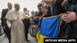 Папа Рымскі Францішак на сустрэчы зь вернікамі, якія трымаюць украінскі сьцяг. Ватыкан. 16 сакавіка 2022