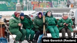 Комунальні працівники відпочивають після прибирання снігу, Київ, 8 лютого 2021 року