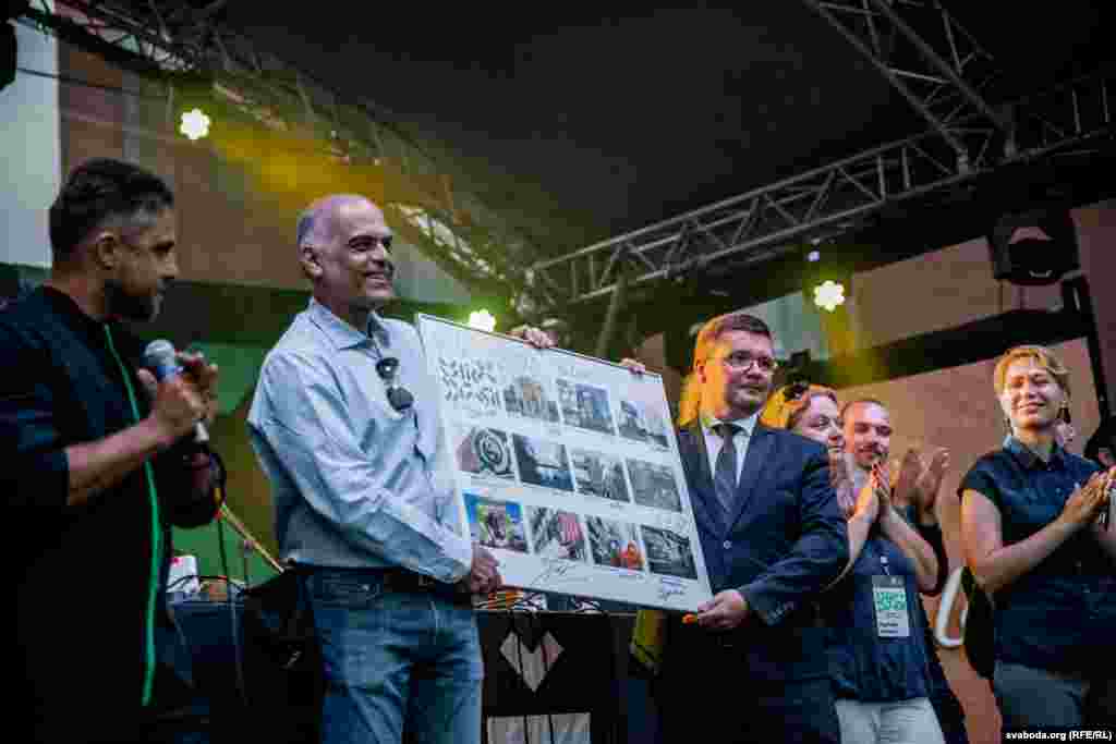 Амбасадар Бразыліі Паўлу Фэрнанду Дыяс Фэрэс перадае кіраўніку адміністрацыі Ленінскага раёну Пятру Шостаку падарунак для гораду — муралы і арт-інсталяцыі ад бразыльскіх і беларускіх мастакоў.
