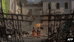 Рятувальники на місці одного з попередніх російських ударів по Сумах, 14 квітня 2025 року