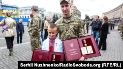 Тарас Лоскот тримає нагороду свого батька – Героя України, капітана Євгена Лоскота, якого посмертно нагородили орденом «Золотої зірки». Поряд лейтенант Василь Тарасюк, який також був удостоєний звання Героя України та нагороджений найвищою військовою нагородою