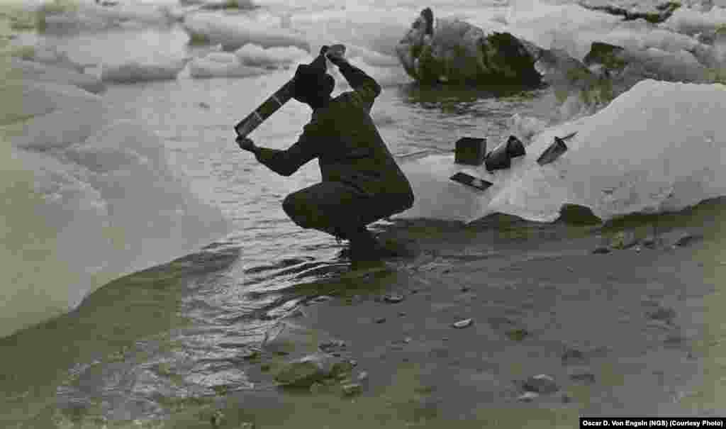 Фотограф Оскар де вон Энгельн моет фотопленку в морской воде, будучи участником экспедиции на Аляску в 1909 году, спонсируемую обществом National Geographic. 