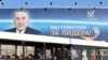 Люди едут в автобусе рядом с баннером с изображением президента Казахстана Нурсултана Назарбаева в Астане. Иллюстративное фото.