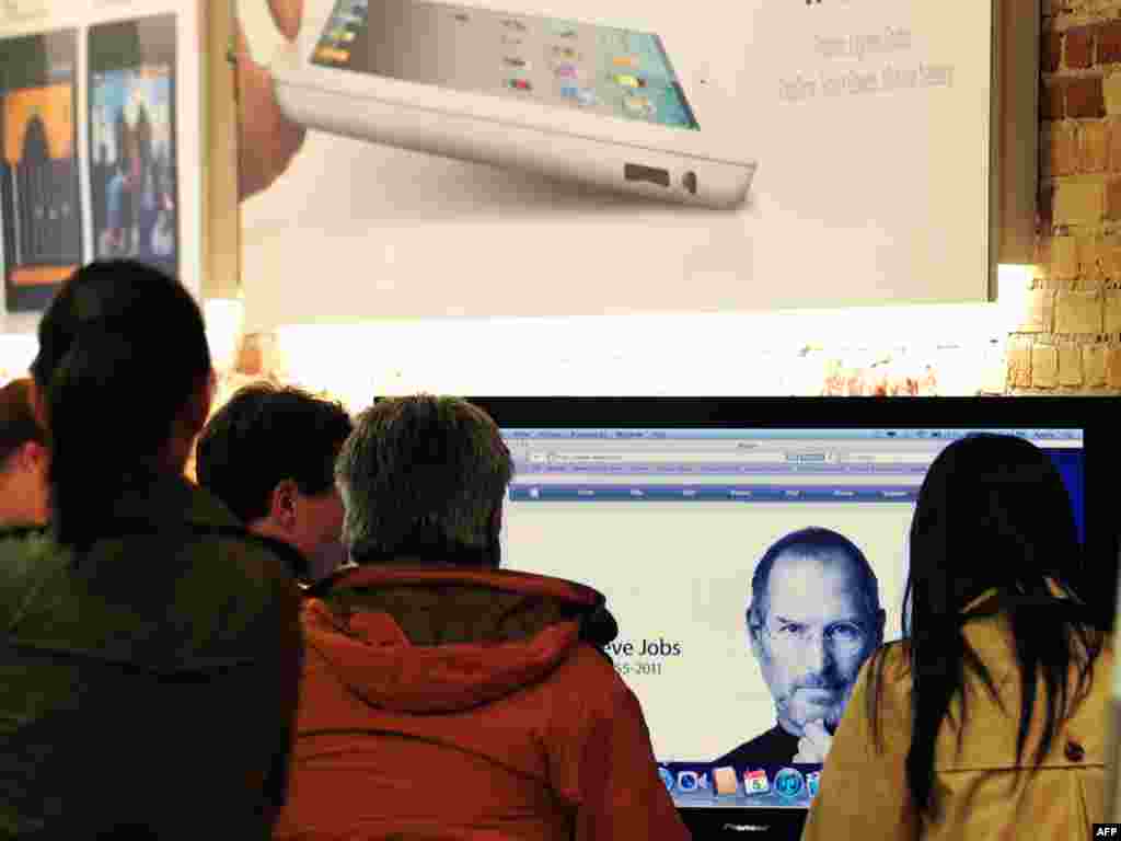 Visitors to an Apple store in Pasadena, California, view a screen from the Apple website announcing Jobs' passing on October 5.